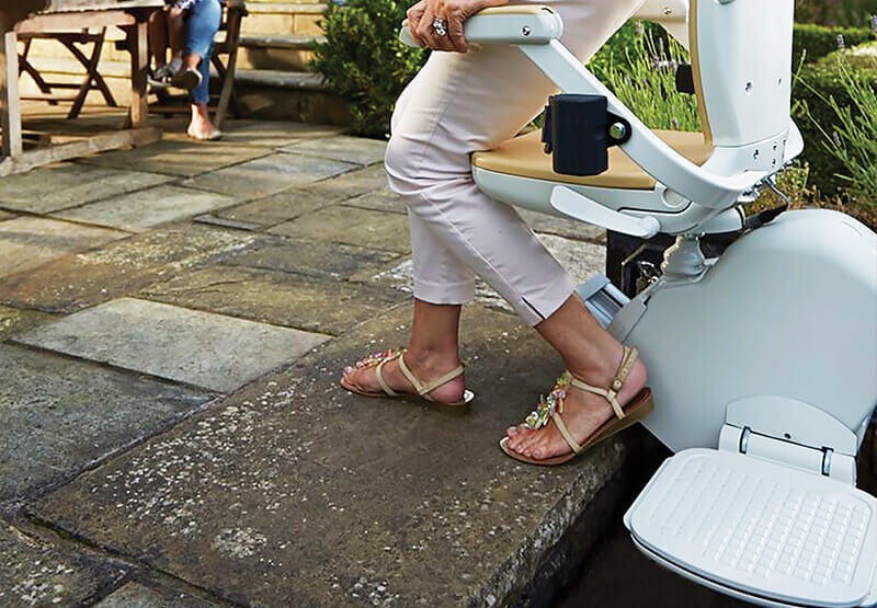 lady stepping off an outdoor acorn stairlift